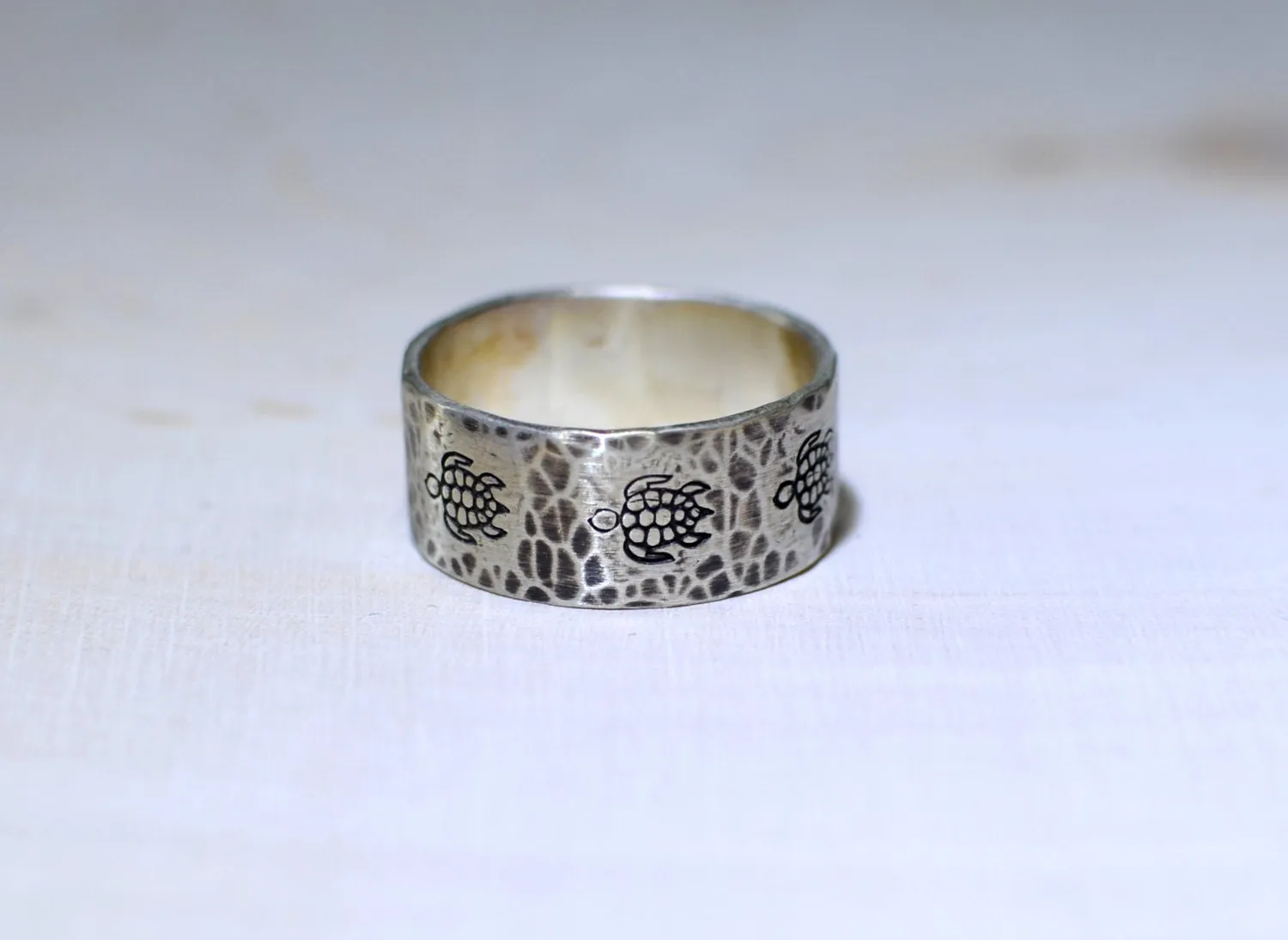 Sterling silver ring with rustic sea turtles and hammered patterning